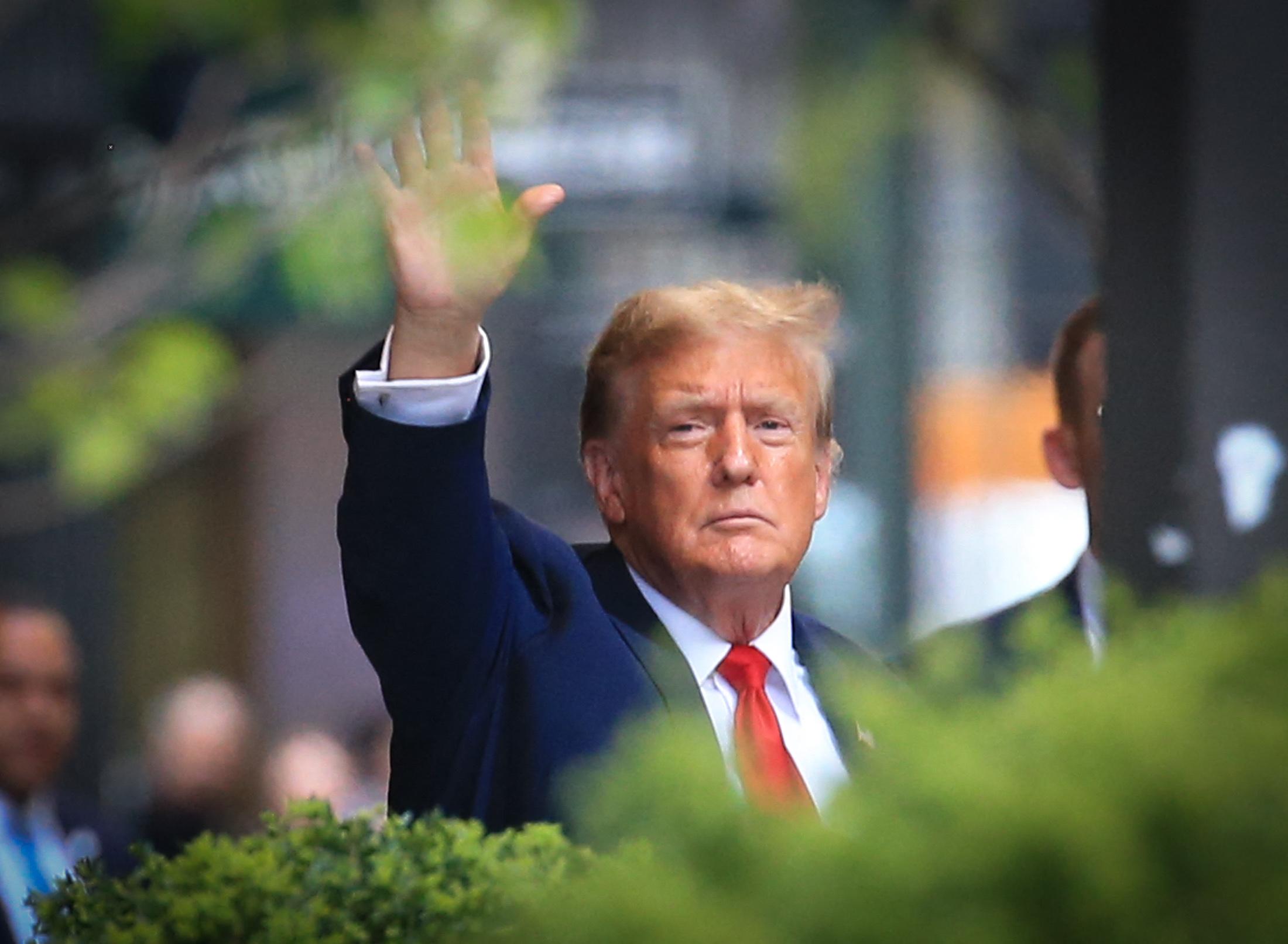 Donald Trump waves as he leaves Trump Tower