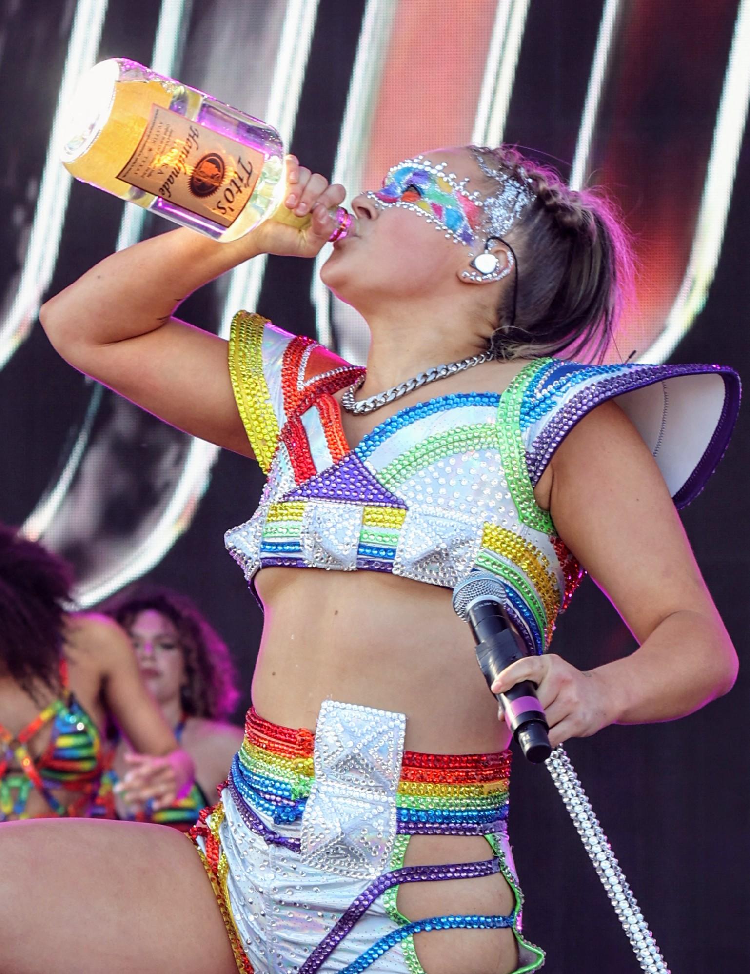 Jojo Siwa chugs from a Titos vodka bottle after just turning 21 as she performs for the Los Angeles Gay Pride celebration with mom watching on